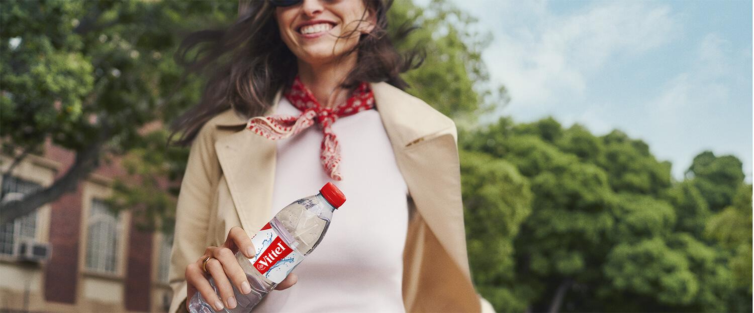 a woman with a VITTEL water bottle